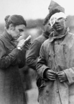 Una donna corrispondente di guerra intervista un soldato ferito.